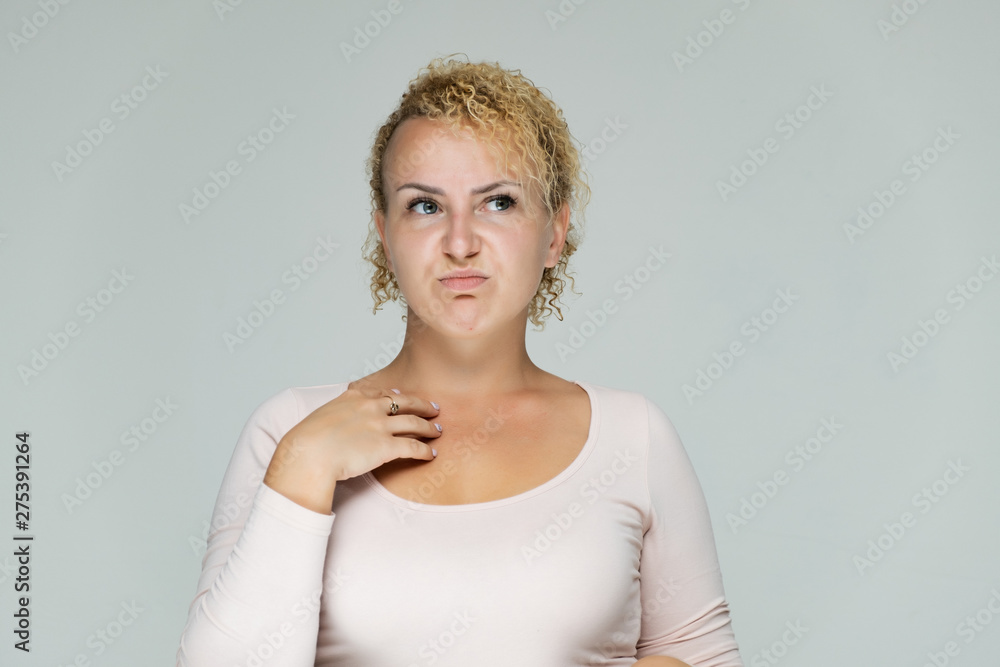 Fototapeta premium Photo portrait of a beautiful girl blonde woman with short curly hair on a white background talking and showing a lot of emotions. An experienced model shows hands. Beauty.
