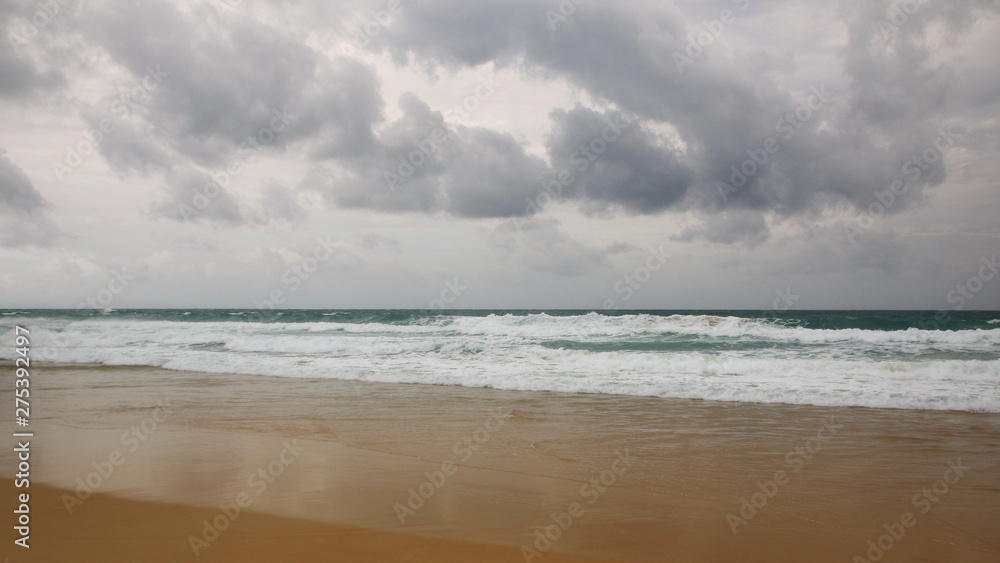 Sunset on Karon beach. Heavy clouds over the sea. The surf pounds the shore. Phuket, Thailand Sunset on Karon beach. Heavy clouds over the sea. The surf pounds the shore. Phuket, Thailand