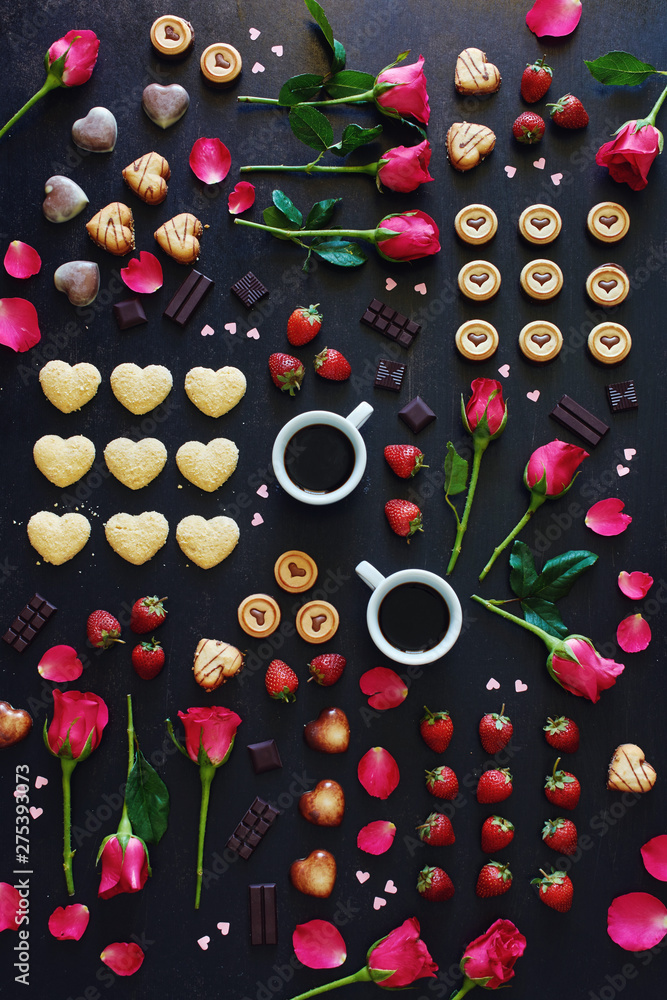 Top view of heart shaped chocolate and cookies, roses, strawberry and coffee over black background. St Valentines or Women day concept. Top view of heart shaped chocolate and cookies, roses, strawberry and coffee over black background. St Valentines or Women day concept.