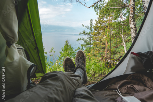 View from the tent on lake Baikal among the pine trees from the hill. Recreation in the beautiful places of the planet.