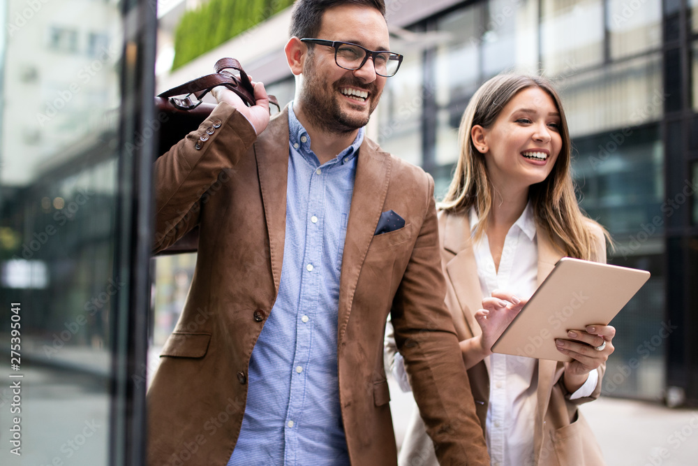 Business people discussing and smiling while walking together outdoor Business people discussing and smiling while walking together outdoor