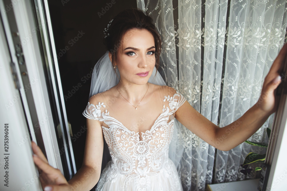 Fototapeta premium Beautiful bride style. Wedding girl stand in luxury wedding dress near window