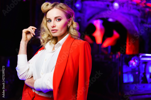 Portrait of young blonde in red suit in nightclub