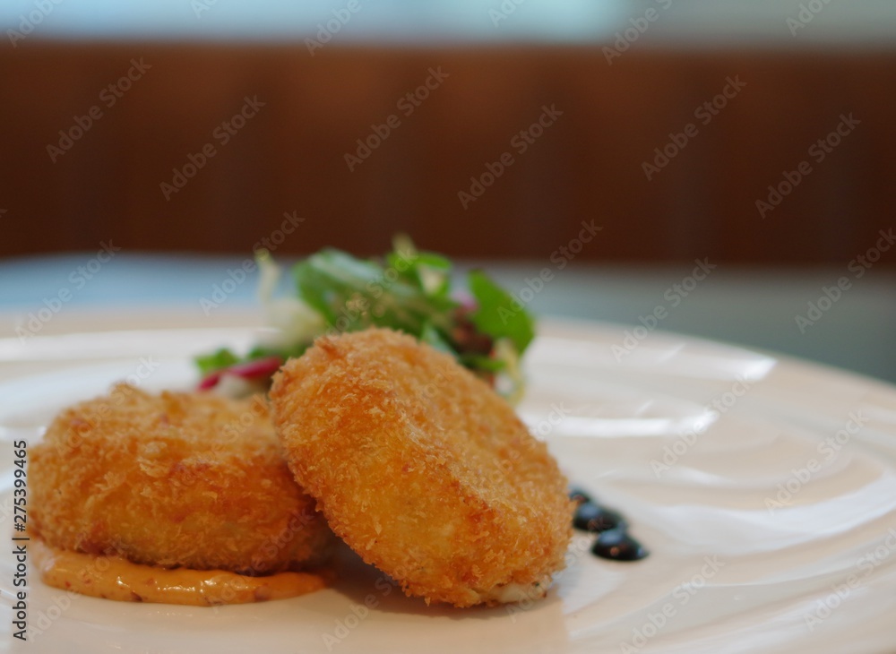 crispy fried croquettes potato beef meat korokke with sauce on white plate with vegetable crispy fried croquettes potato beef meat korokke with sauce on white plate with vegetable