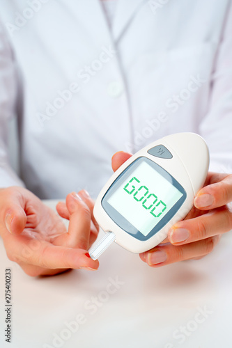 Photo of hand man with glucometer with words good in studio