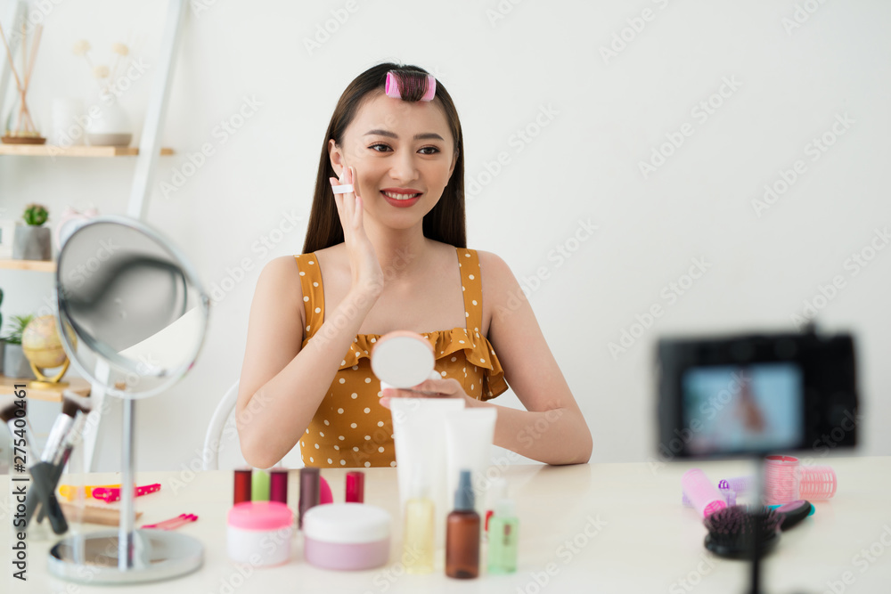 Best powder. Pleasant young woman showing her cosmetics on camera while recommending it to her viewers Best powder. Pleasant young woman showing her cosmetics on camera while recommending it to her viewers