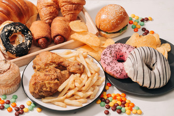 fast food and unhealthy eating concept - close up of fast food snacks and cola drink on white table