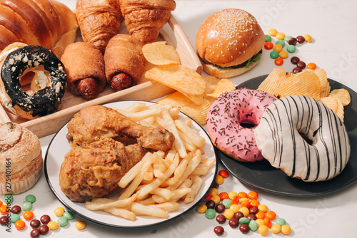 fast food and unhealthy eating concept - close up of fast food snacks and cola drink on white table