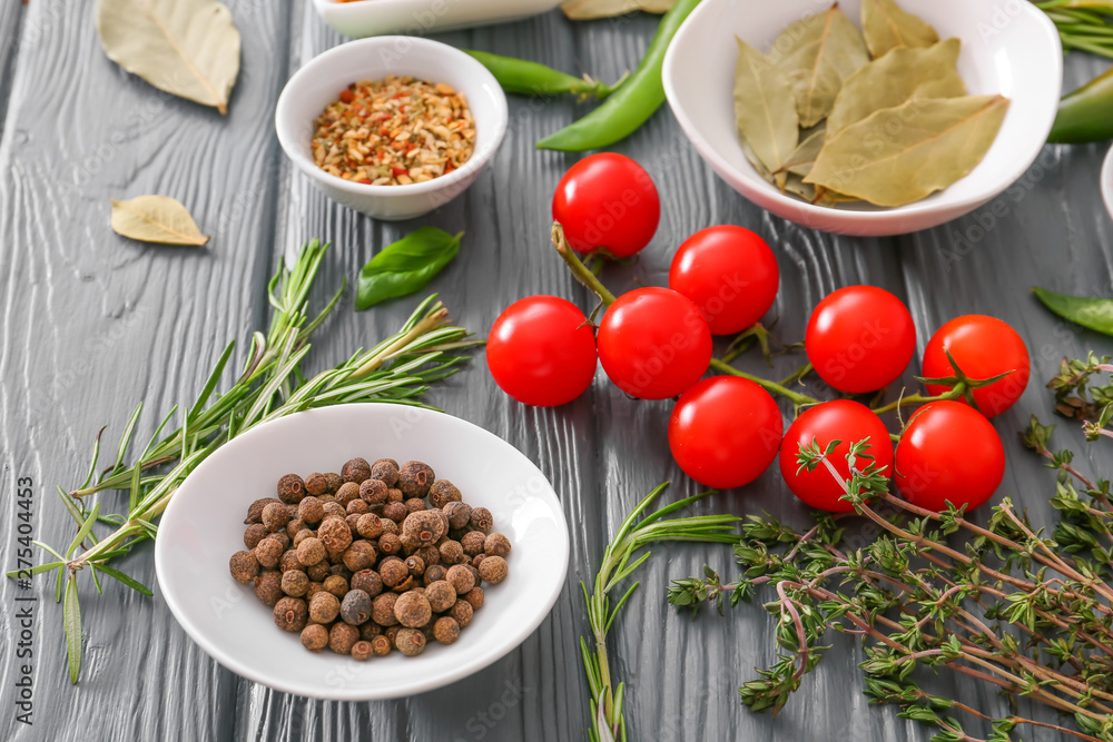 Spices with fresh herbs and tomatoes on wooden table Spices with fresh herbs and tomatoes on wooden table