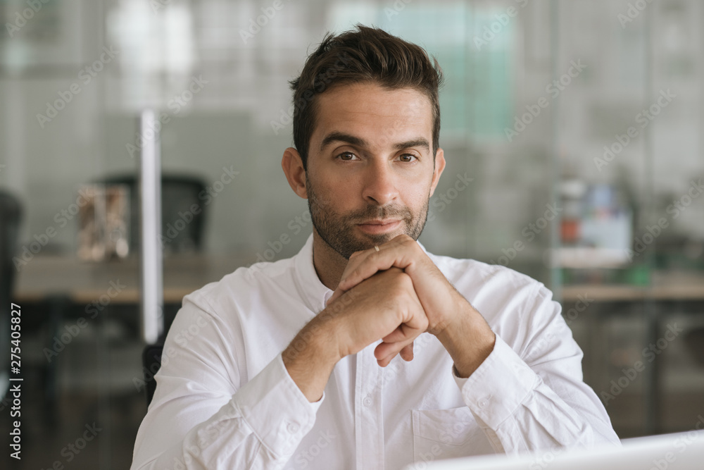 Naklejka premium Focused young businessman sitting alone in a modern office