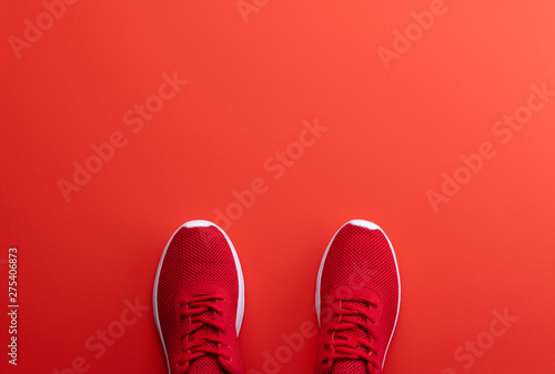 A studio shot of pair of running shoes on red background. Flat lay.