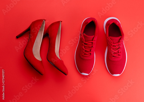 A studio shot of pair of running vs high heel shoes on color background. Flat lay.