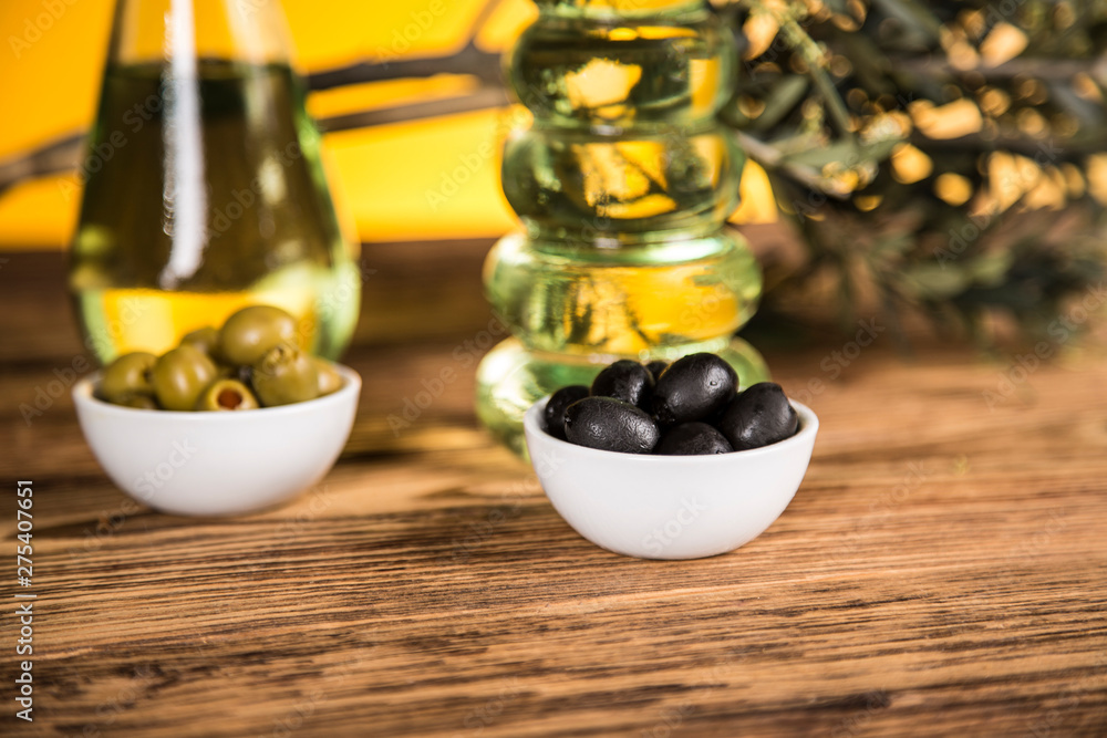 Olive oil, olive tree and green and black olives on a wooden table Olive oil, olive tree and green and black olives on a wooden table