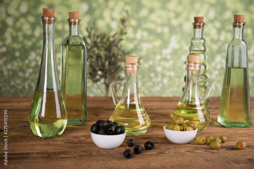 Olive oil, olive tree and green and black olives on a wooden table Olive oil, olive tree and green and black olives on a wooden table