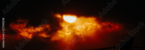 View of the sun behind the clouds during the sunset