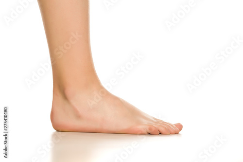 Side view of female bare foot on white background © Jasmina