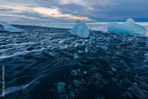 Ice blocks on the black sand beach during sunset in Iceland