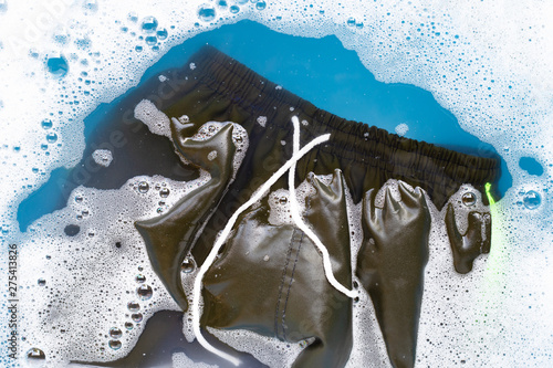 Male shorts soak in powder detergent water dissolution. Laundry concept