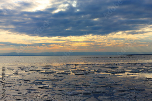 Ice floes in a dramatic sunset color on the lake at winter