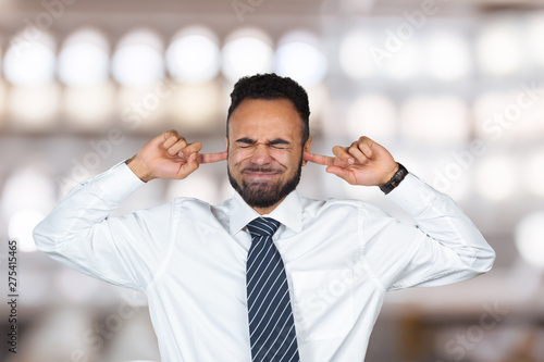 Obraz na plátně I don`t want to hear it! Dark-skinned male closing ears with fingers