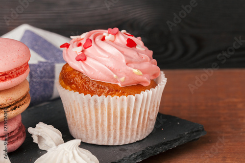 Delicious raspberry and caramel cupcakes on dark background