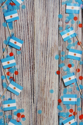 July 9. Independence day of Argentina, the concept of the Day of memory, freedom and patriotism. Mini flags with paper confetti on wooden white background, vertical