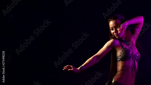 Wallpaper Mural close-up of sexy girl who is dancing Oriental dance on dark background, she is wearing Oriental costume. It's lit up with purple light. Torontodigital.ca