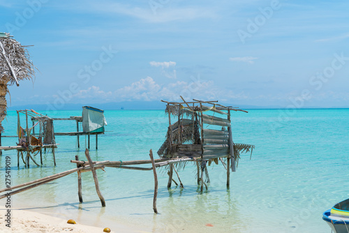 Thatched structures over waters edge on tropical island. © Brian Scantlebury