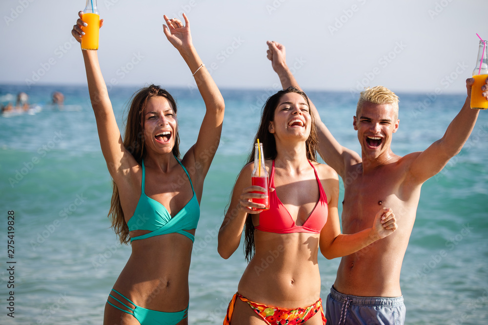 Group of happy friends enjoying the beach at summer
