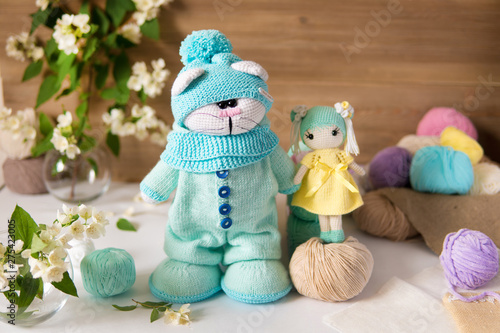 Knitted toy cat and girl Handmade on wooden table. Crochet stuffed animals.