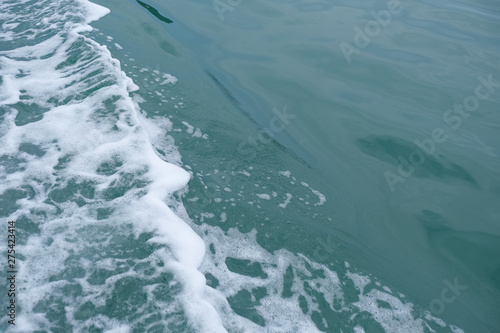 Trail on the water from the boat, sea waves bubble foam from boat. Stock photo image of ocean waves and sea foam caused by the sail of a speed boat, water surface behind of fast moving motor boat