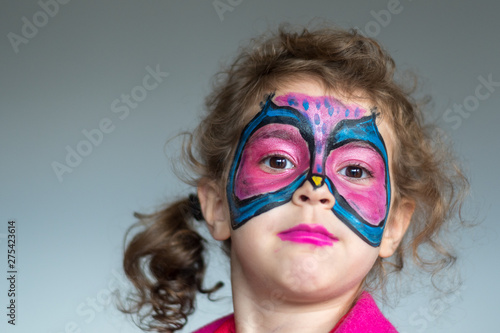 Isolated close up portrait of a five year old girl with a butterfly makeup costume