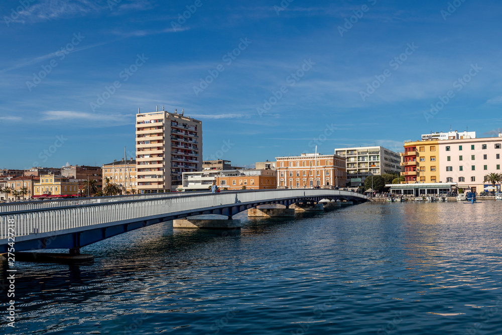 People cross the city bridge in Jazine bay in the town Zadar on a sunny day, Croatia