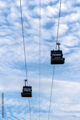 cableway cabins on a background of blue sky and white clouds in sunny summer weather