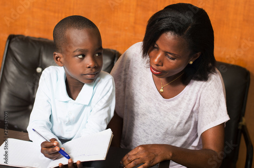 the child shows something to her mom in his notebook. photo