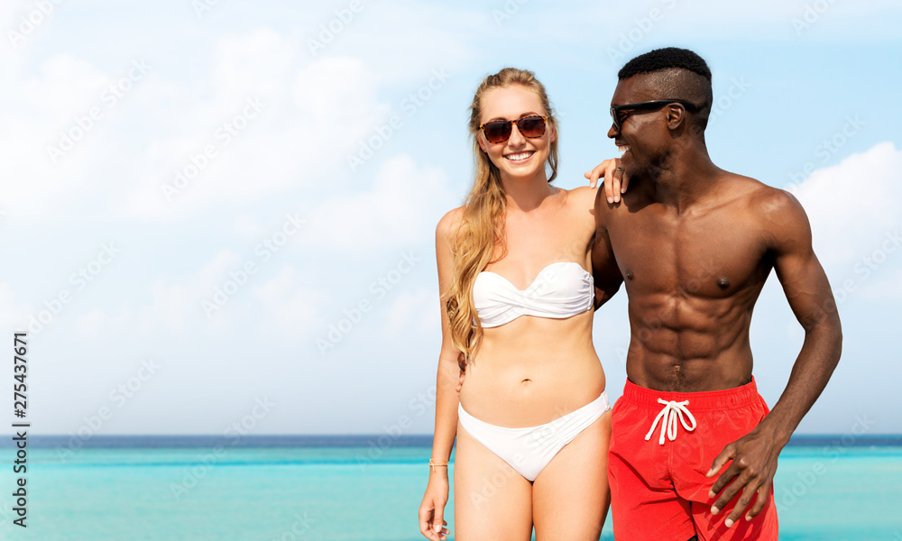 friendship, summer holidays and relationships concept - happy mixed race couple over beach background in french polynesia friendship, summer holidays and relationships concept - happy mixed race couple over beach background in french polynesia