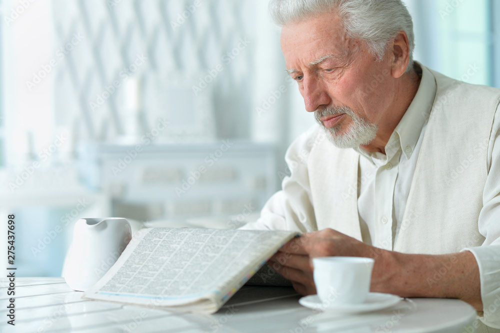 Portrait of emotional senior man reading newspaper Portrait of emotional senior man reading newspaper