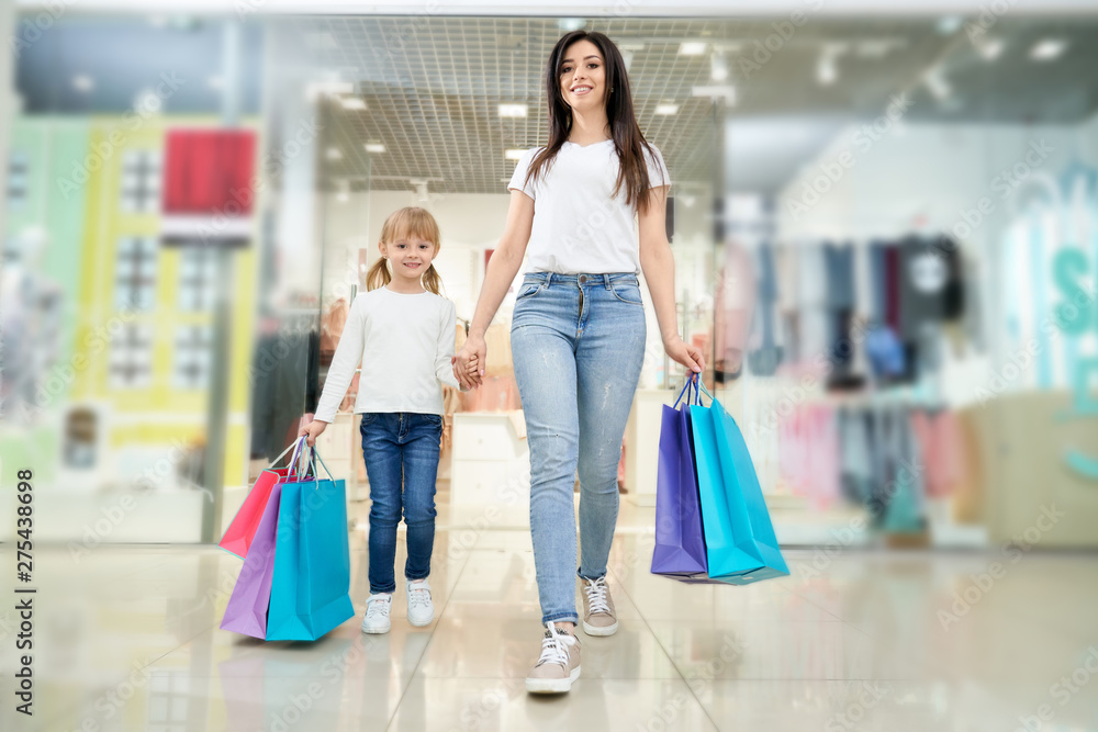Front view of woman shopping together with daughter in mall Front view of woman shopping together with daughter in mall