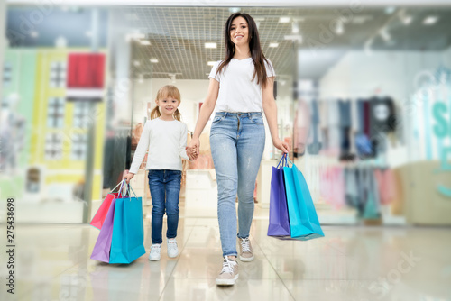 Front view of woman shopping together with daughter in mall
