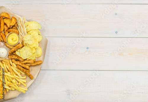 Assorted snacks  on light wooden background. Empty space for text. Top view