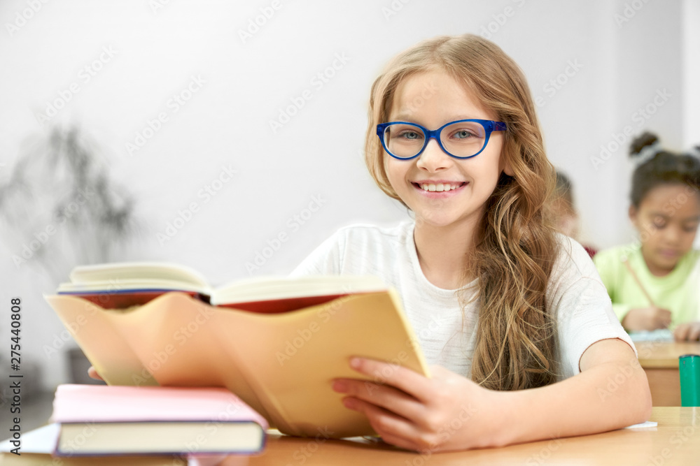 Portrait of schoolgirl sitting and posing in classroom. Portrait of schoolgirl sitting and posing in classroom.