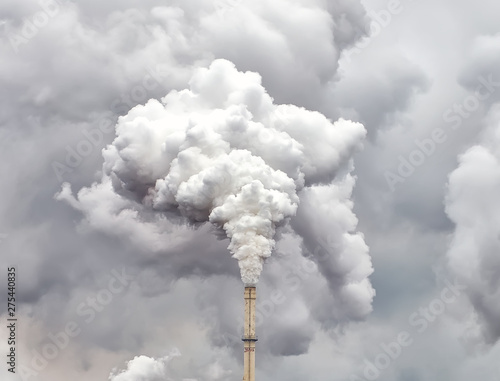 Smoke from factory pipe against dark overcast sky photo