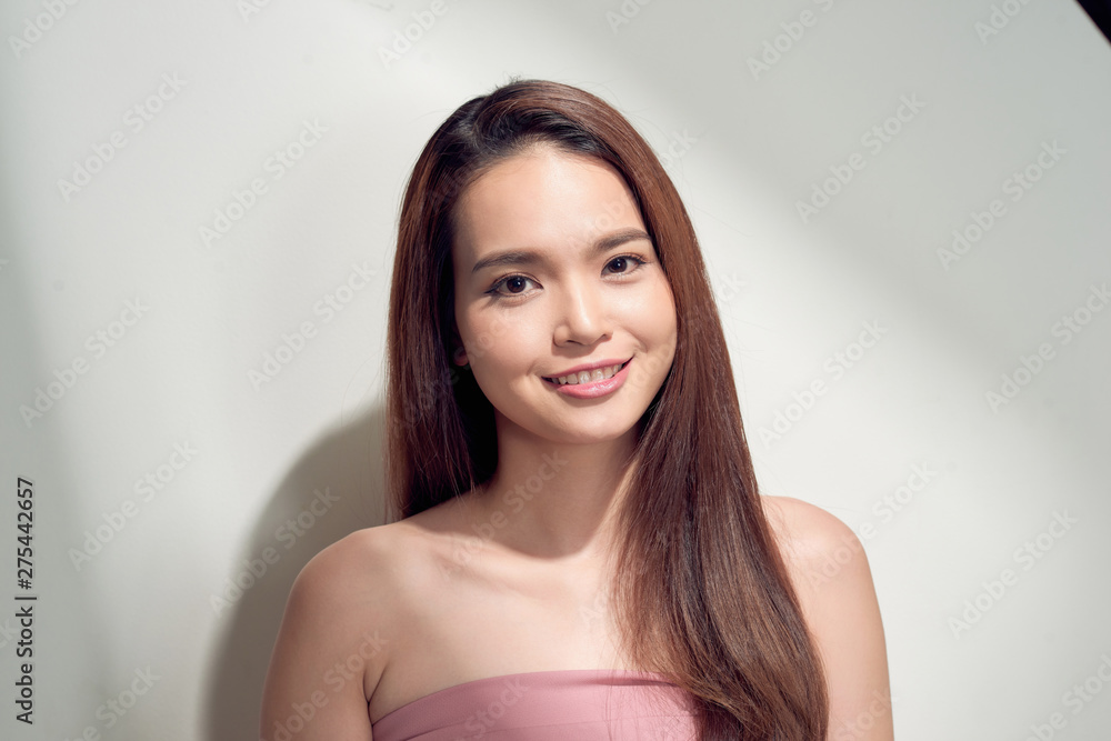 Elegant asian girl with tanned skin posing with pensive face expression on bright background. Elegant asian girl with tanned skin posing with pensive face expression on bright background.
