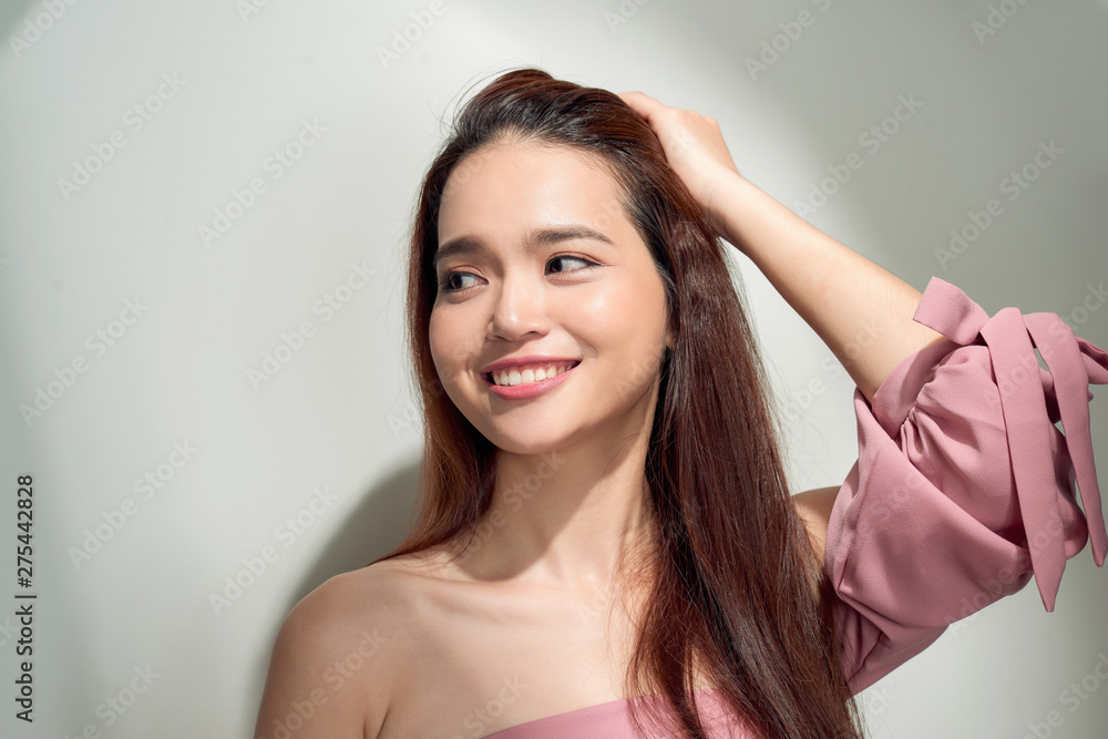Spectacular asian young woman playing with her hair. Indoor photo of wonderful female model isolated on white background Spectacular asian young woman playing with her hair. Indoor photo of wonderful female model isolated on white background