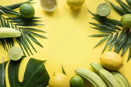 Tropical border of fruits, banana, lime, leaves palms on yellow background. Space for text. Detox tour. photo