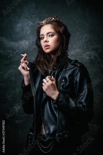 Young woman wearing a wreath, smoking a cigarette, a drink in her hand