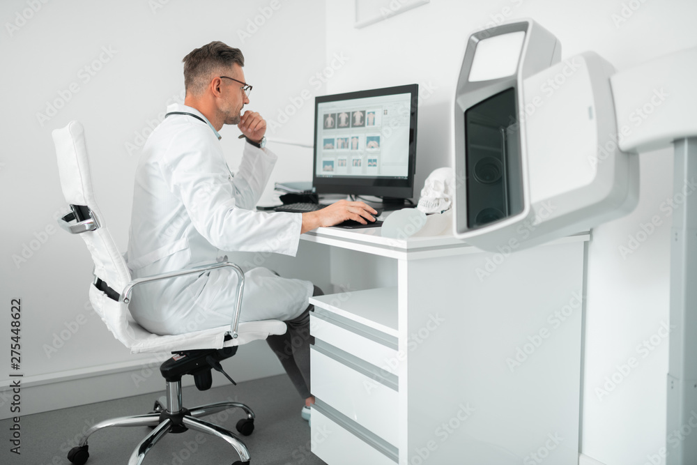 Obraz premium Professional plastic surgeon sitting at the computer while working