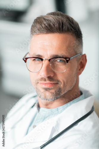 Fototapeta Naklejka Na Ścianę i Meble -  Handsome bearded blue-eyed plastic surgeon wearing glasses