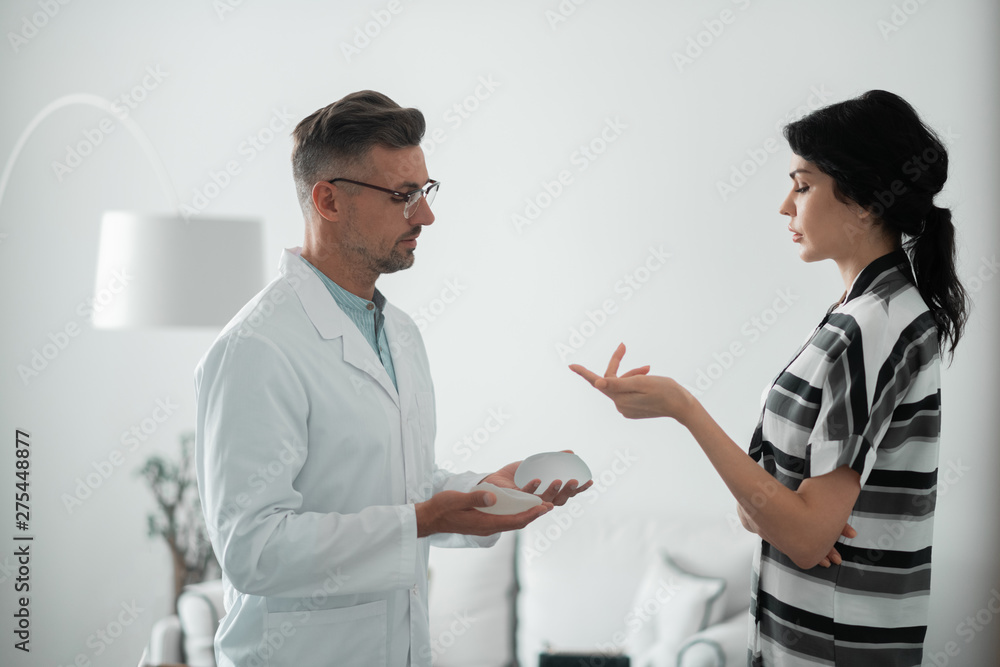 Fototapeta premium Dark-haired woman asking questions about implants for breast