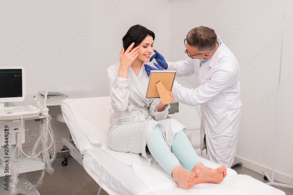 Fototapeta premium Dark-haired woman feeling satisfied after nasal surgery